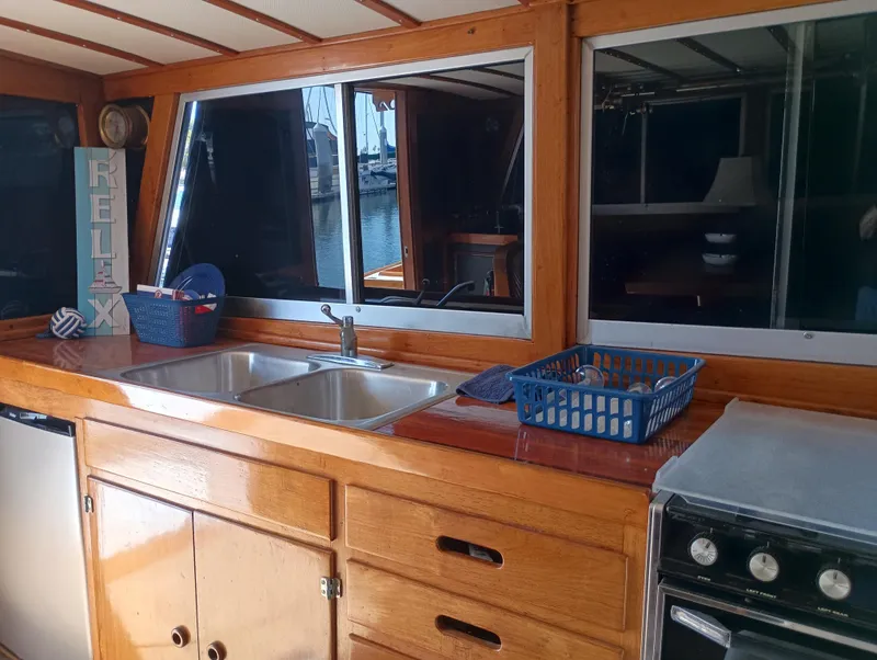 Slide: The Image of 1978 Pacific Bluefin SPF boat kitchen with wooden cabinets, dual sink, and stove. - 28
