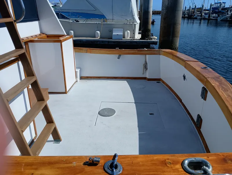 Slide: The Image of 1978 Pacific Bluefin SPF boat deck with wooden railings, docked at a marina. - 3