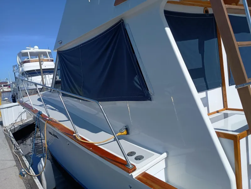 Slide: The Image of 1978 Pacific Bluefin SPF boat docked, featuring sleek design and blue canvas covers. - 36