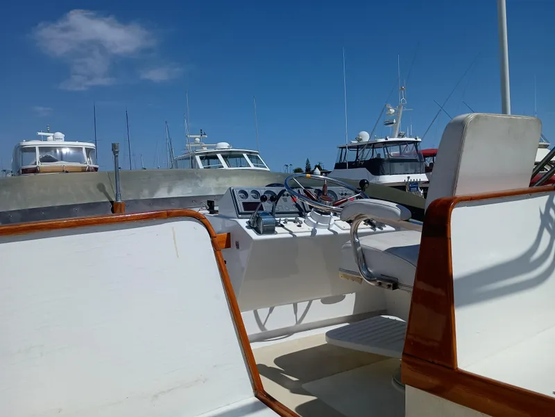 Slide: The Image of 1978 Pacific Bluefin SPF boat interior with steering wheel, docked under clear blue sky. - 41