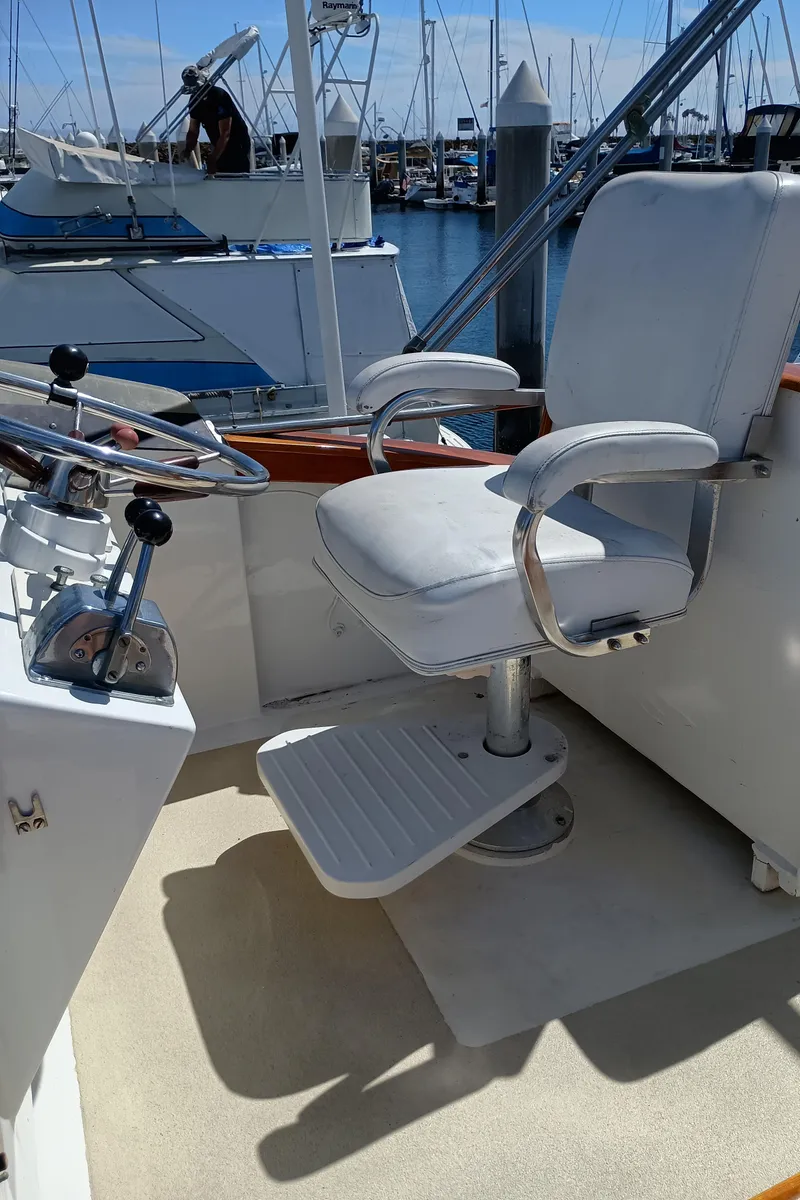 Slide: The Image of Captain's chair on a 1978 Pacific Bluefin SPF boat, docked at a marina. - 44