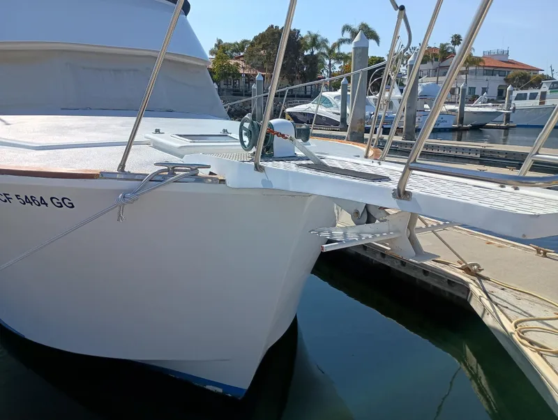 Slide: The Image of 1978 Pacific Bluefin SPF boat docked at a marina, featuring a sleek white hull. - 48