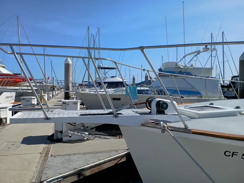 Slide: The Image of Marina with docked boats, featuring a 1978 Pacific Bluefin SPF model under clear blue skies. - 49