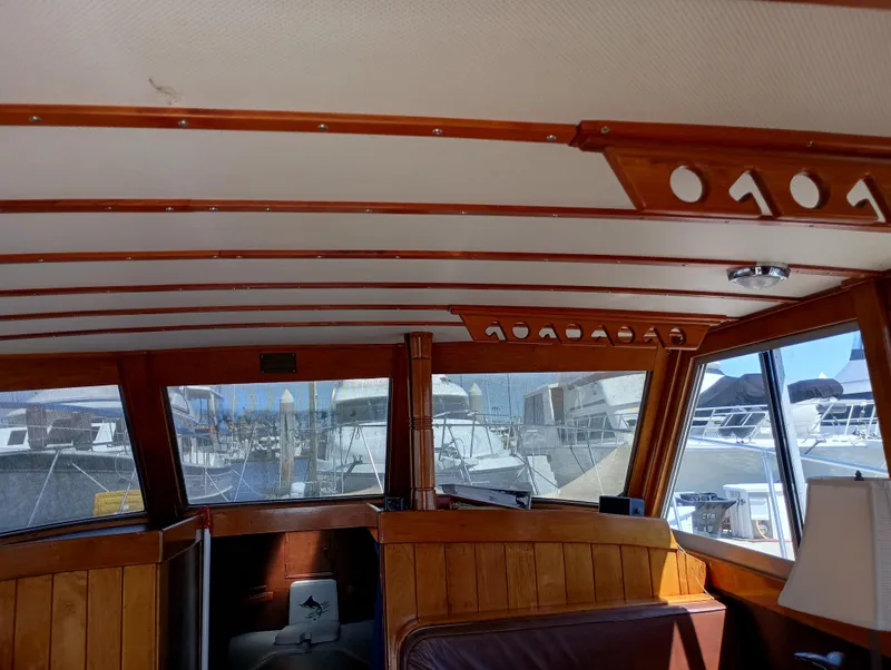 Slide: The Image of Interior of a 1978 Pacific Bluefin SPF boat with wooden paneling and large windows. - 8