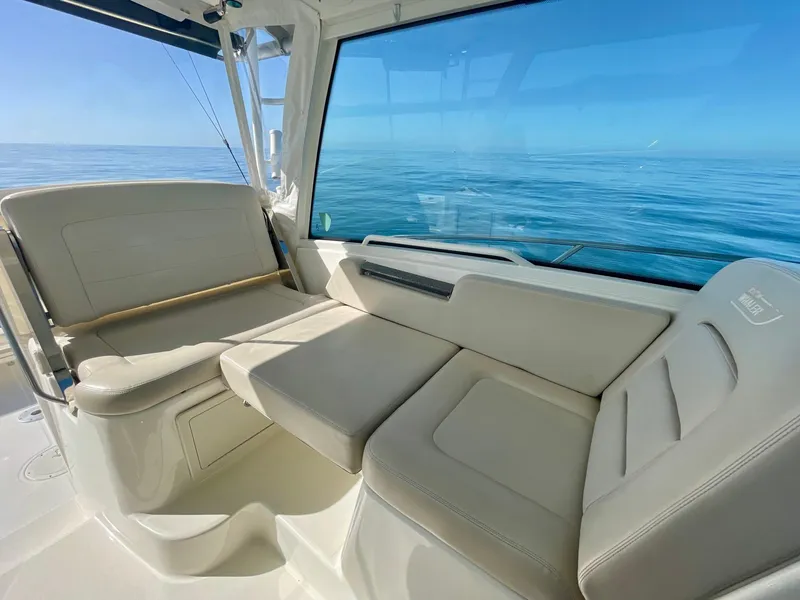 Slide: The Image of 2018 Boston Whaler 315 Conquest interior with beige seating, ocean view. - 17