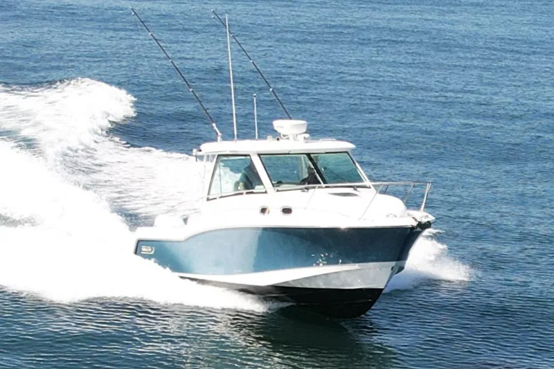 Slide: The Image of 2018 Boston Whaler 315 Conquest cruising on open water, showcasing sleek design and performance. - 2