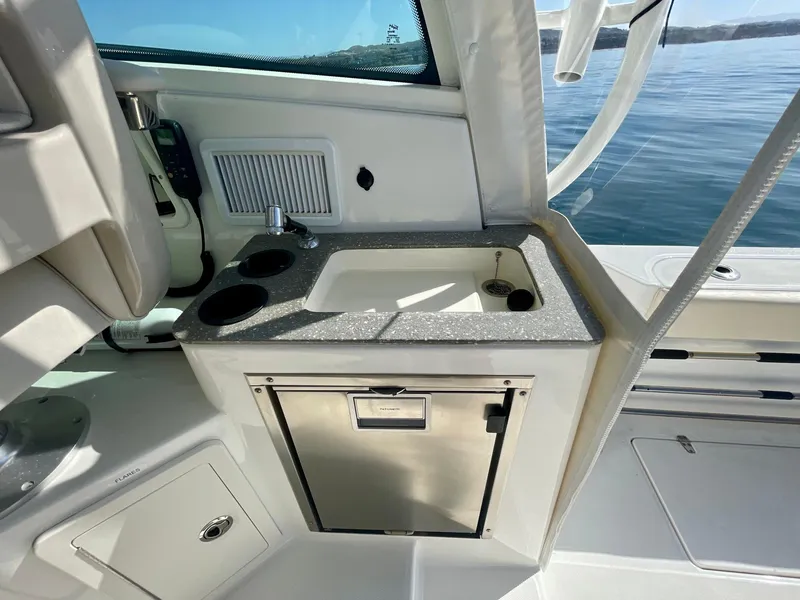 Slide: The Image of 2018 Boston Whaler 315 Conquest boat interior with sink and storage. - 20