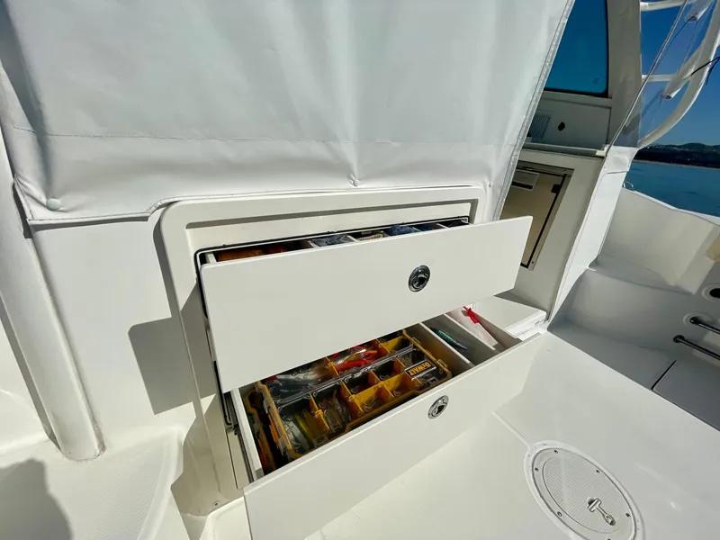 Slide: The Image of 2018 Boston Whaler 315 Conquest boat with open storage drawer, showcasing organized compartments. - 22