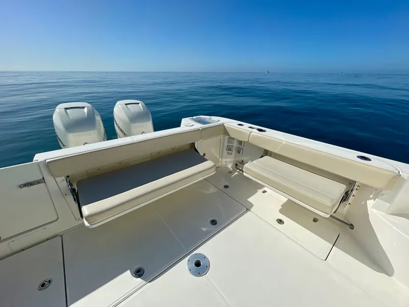 Slide: The Image of 2018 Boston Whaler 315 Conquest boat deck with twin engines on calm sea. - 26