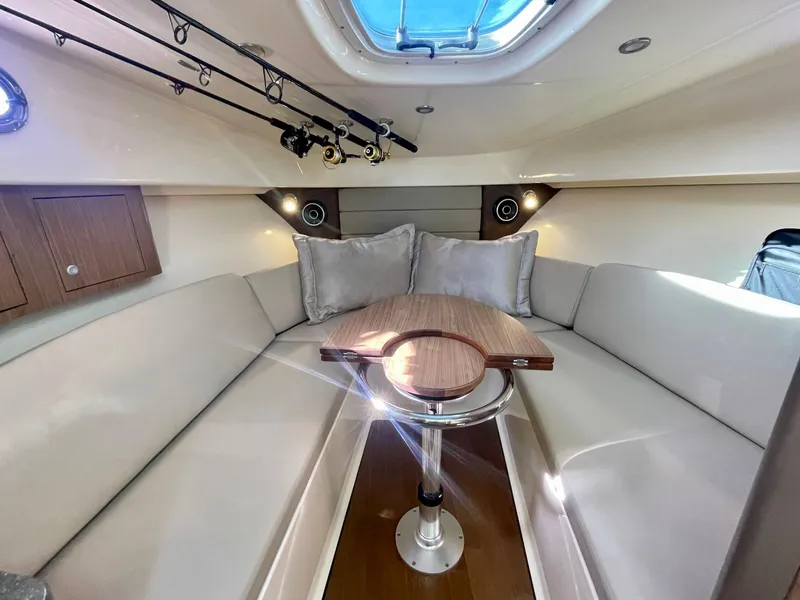 Slide: The Image of 2018 Boston Whaler 315 Conquest cabin interior with seating and table. - 27