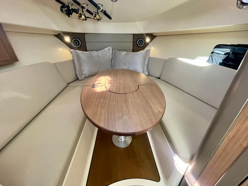 Slide: The Image of 2018 Boston Whaler 315 Conquest cabin with cozy seating and wooden table. - 32