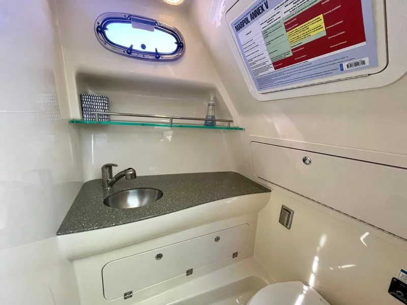 Slide: The Image of 2018 Boston Whaler 315 Conquest bathroom with sink, storage, and porthole window. - 44