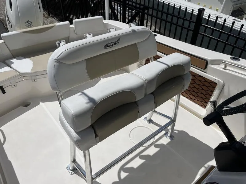 Slide: The Image of 2020 Bulls Bay 230 Center Console boat seating with cushioned bench and steering area. - 14