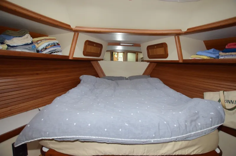 Slide: The Image of Cozy cabin interior of 2006 Legacy Yachts Sedan with neatly arranged bedding and wooden shelves. - 13