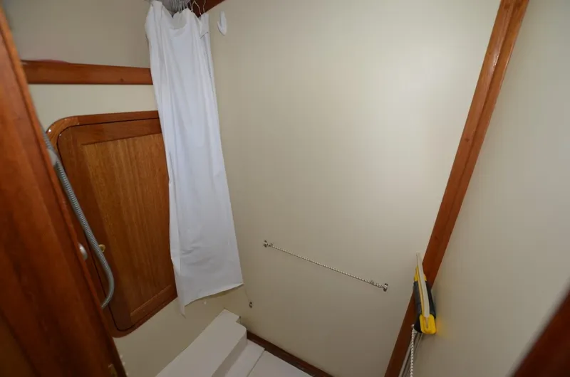 Slide: The Image of 2006 Legacy Yachts Sedan bathroom with wooden accents and shower curtain. - 15