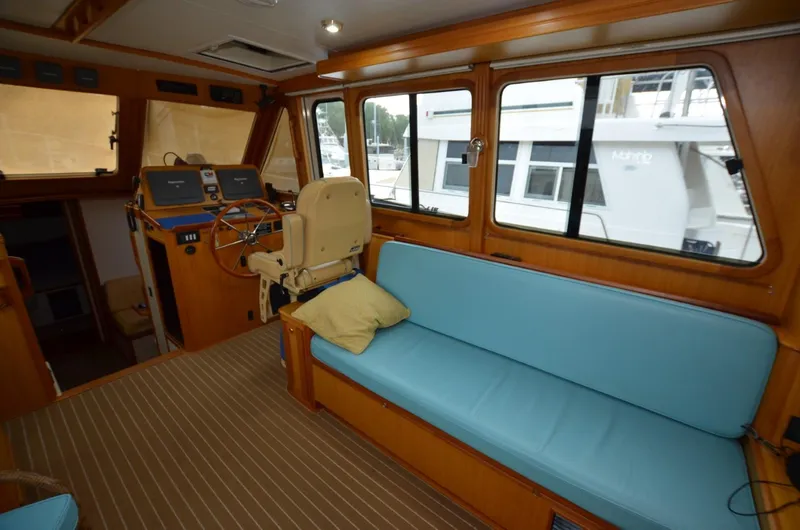 Slide: The Image of 2006 Legacy Yachts Sedan interior with blue seating, helm station, and large windows. - 5