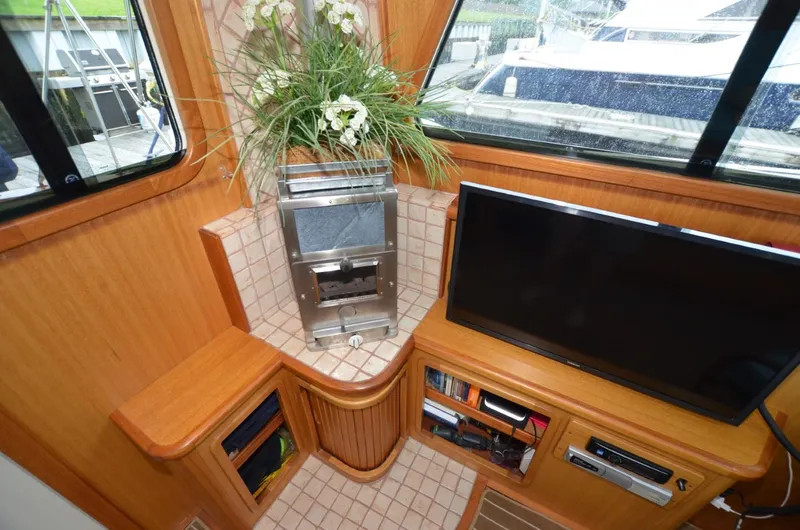 Slide: The Image of Interior of 2006 Legacy Yachts Sedan with TV, fireplace, and floral arrangement. - 7