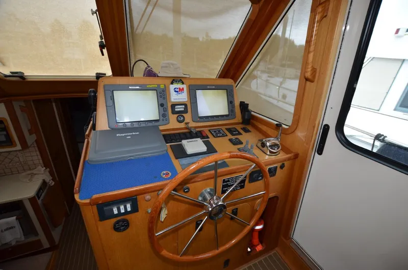 Slide: The Image of 2006 Legacy Yachts Sedan helm with navigation equipment and wooden steering wheel. - 8