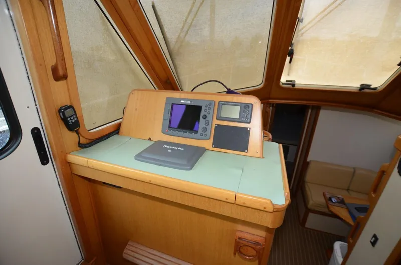 Slide: The Image of 2006 Legacy Yachts Sedan interior helm with navigation equipment and wooden finish. - 9