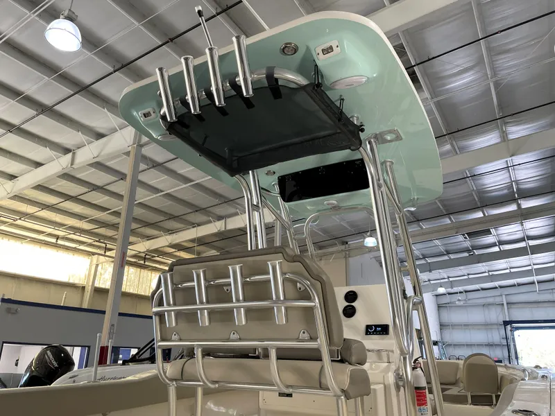 Slide: The Image of 2024 Key West 239 FS boat interior with rod holders and T-top in a showroom. - 18