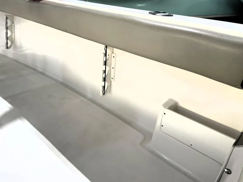 Slide: The Image of 2024 Key West 239 FS boat interior detail with storage compartment and cushioned side panel. - 48