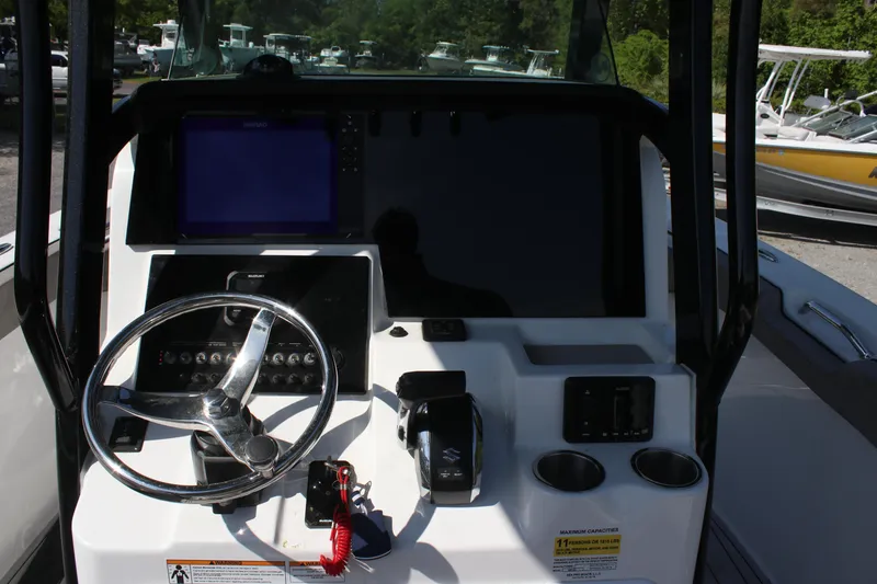 Slide: The Image of 2023 Sea Pro 239 Deep V CC boat console with steering wheel and navigation controls. - 13