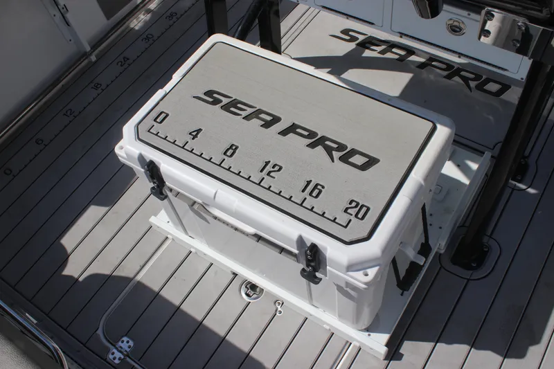 Slide: The Image of 2023 Sea Pro 239 Deep V CC boat deck with branded cooler and measuring scale. - 7