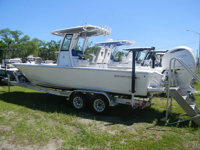 The Image of 2025 Sportsman Masters 267 Bay Boat on trailer, parked on grass under clear blue sky. - 0