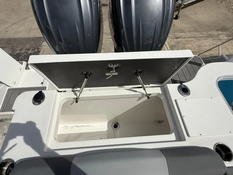 Slide: The Image of Open storage compartment on 2025 NauticStar 292 Legacy boat, with dual outboard motors. - 11