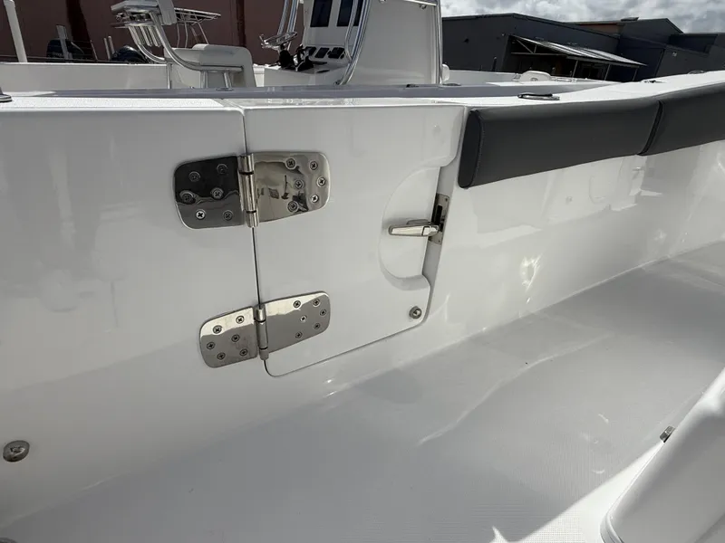 Slide: The Image of 2025 NauticStar 292 Legacy boat interior with stainless steel hinges and cushioned seating. - 13
