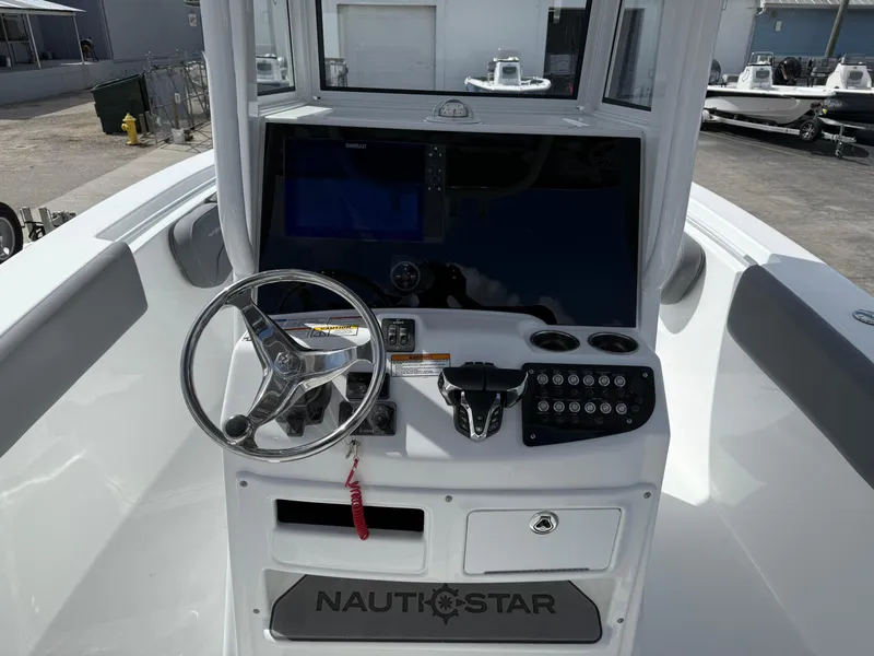 Slide: The Image of 2025 NauticStar 292 Legacy boat console with steering wheel and control panel. - 15