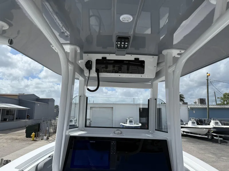 Slide: The Image of 2025 NauticStar 292 Legacy boat console with electronics and overhead storage. - 16