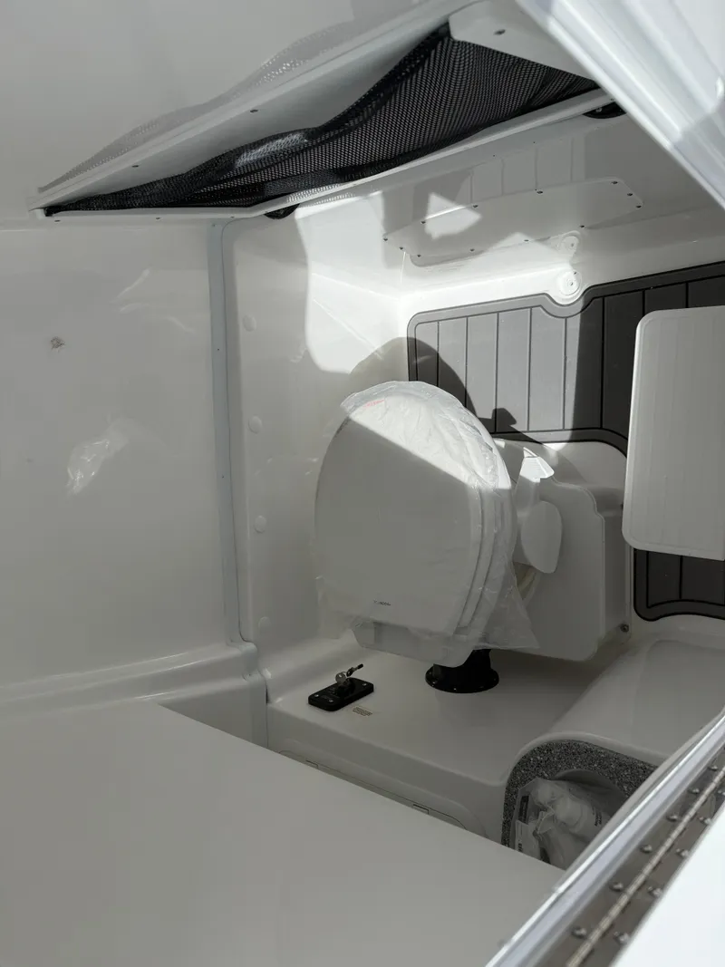 Slide: The Image of 2025 NauticStar 292 Legacy boat interior with a compact marine toilet. - 22