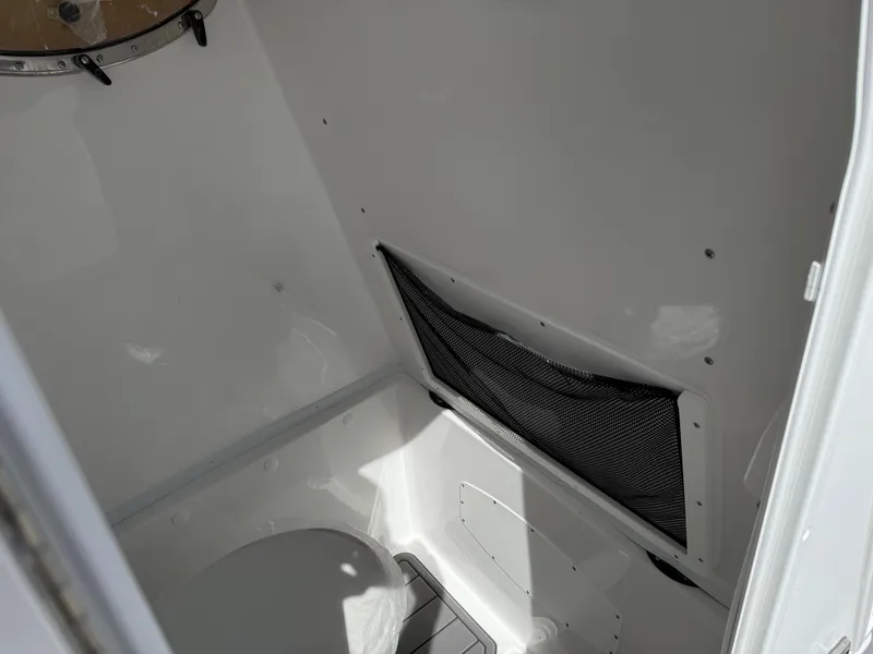 Slide: The Image of Interior of 2025 NauticStar 292 Legacy boat, featuring a compact restroom area. - 23