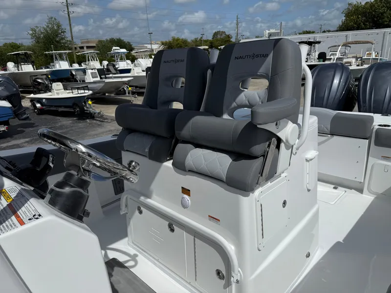 Slide: The Image of 2025 NauticStar 292 Legacy boat with dual captain's chairs and steering wheel. - 24