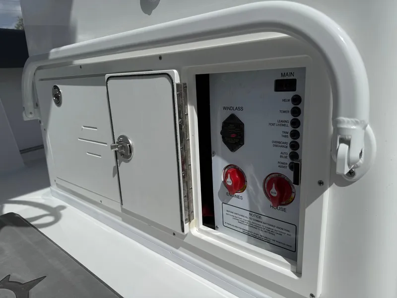 Slide: The Image of Control panel of 2025 NauticStar 292 Legacy boat with switches and storage compartment. - 25