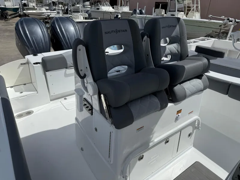 Slide: The Image of 2025 NauticStar 292 Legacy boat with dual cushioned seats and twin outboard motors. - 26