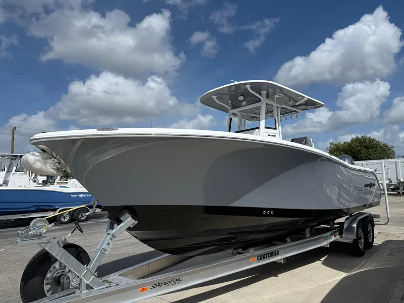Slide: The Image of 2025 NauticStar 292 Legacy boat on trailer under a cloudy sky. - 28