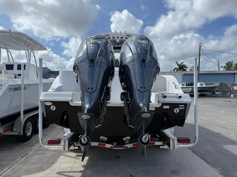 Slide: The Image of 2025 NauticStar 292 Legacy boat with dual outboard engines, docked under a cloudy sky. - 3