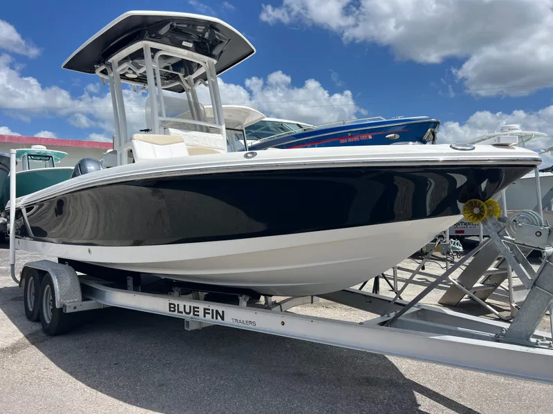 Slide: The Image of 2018 Robalo 226 Cayman boat on trailer under blue sky. - 0