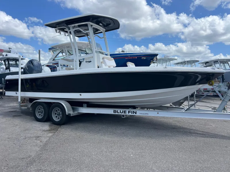Slide: The Image of 2018 Robalo 226 Cayman boat on trailer under blue sky with clouds. - 1
