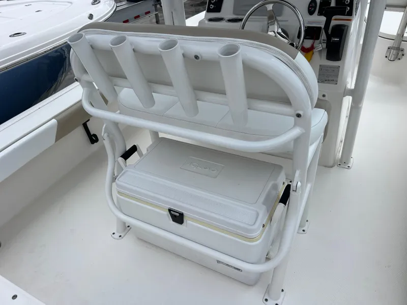 Slide: The Image of 2018 Robalo 226 Cayman boat interior with rod holders and cooler storage. - 8