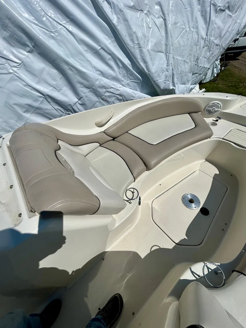Slide: The Image of 2002 Sea Ray 270 Sundeck interior with beige seating and storage compartment. - 12