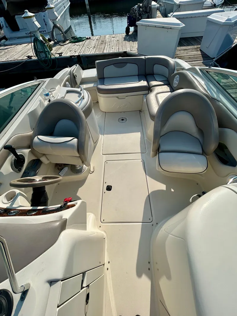 Slide: The Image of 2002 Sea Ray 270 Sundeck interior with seating and steering wheel, docked at marina. - 14