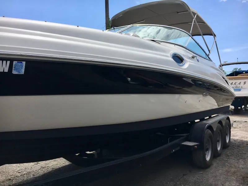 Slide: The Image of 2002 Sea Ray 270 Sundeck boat on a trailer, side view under clear sky. - 19