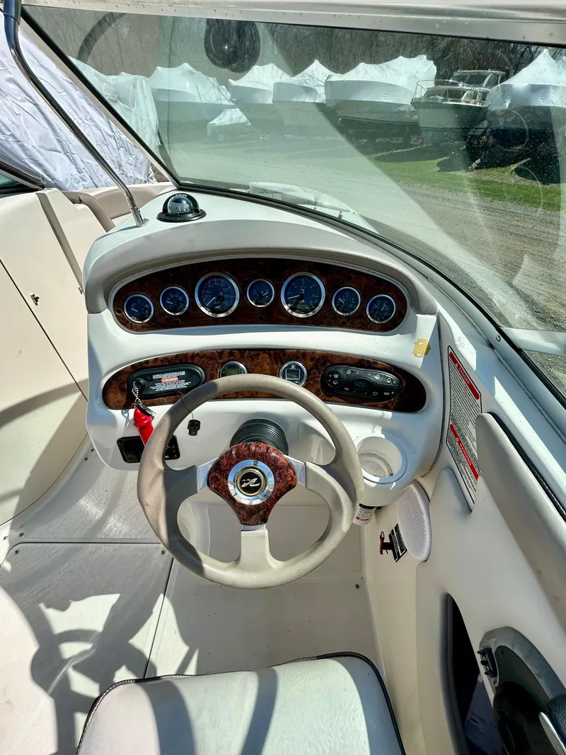 Slide: The Image of Interior cockpit of a 2002 Sea Ray 270 Sundeck boat, featuring steering wheel and dashboard controls. - 3