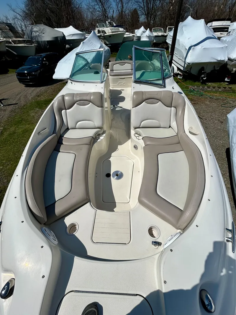 Slide: The Image of 2002 Sea Ray 270 Sundeck boat with spacious seating and dual windshields, docked outdoors. - 5