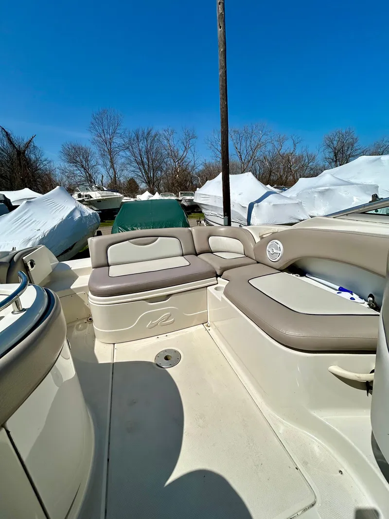 Slide: The Image of 2002 Sea Ray 270 Sundeck interior with beige seating under clear blue sky. - 6