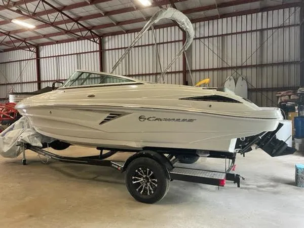 The Image of 2023 Crownline 200 SS boat on trailer in indoor storage facility. - 1