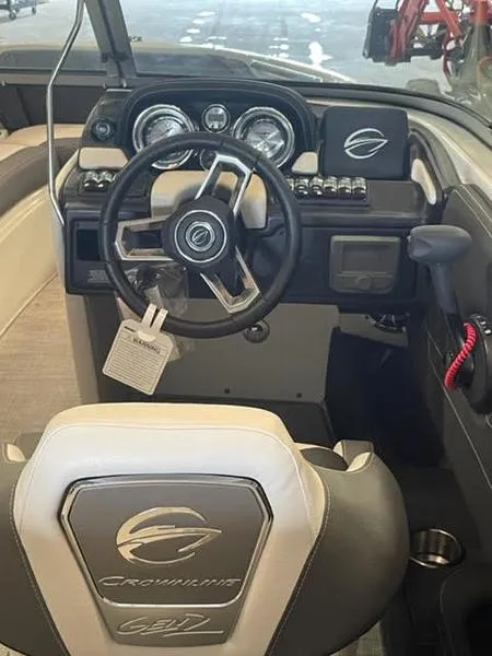 Slide: The Image of 2023 Crownline 200 SS boat interior with steering wheel and dashboard controls. - 6